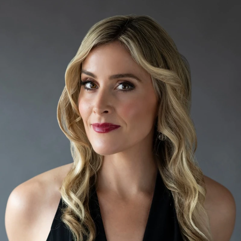 Headshot of Ashlyn Tymms wearing a black halter-neck dress.