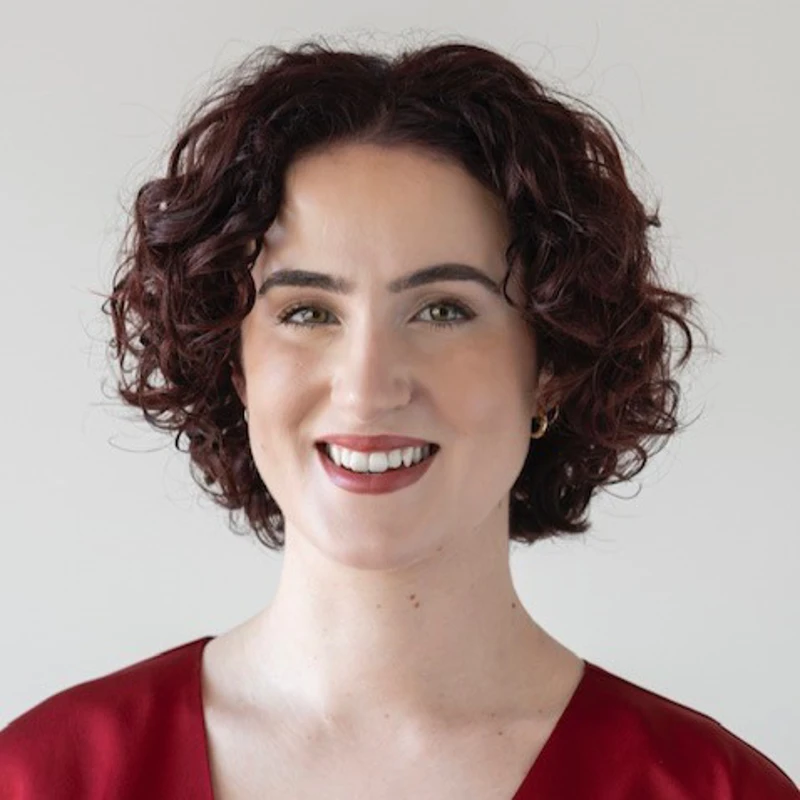 Headshot of Ruth Burke wearing a red satin top.