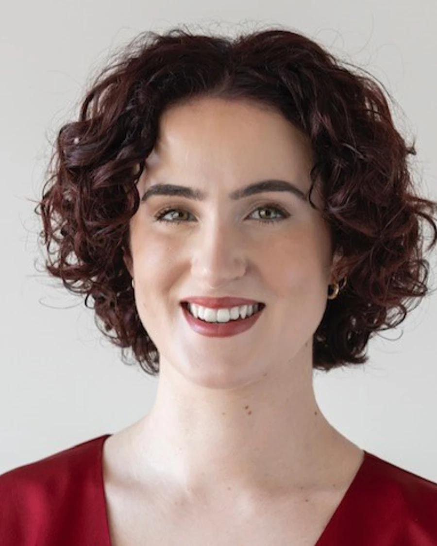 Headshot of Ruth Burke wearing a red satin top.
