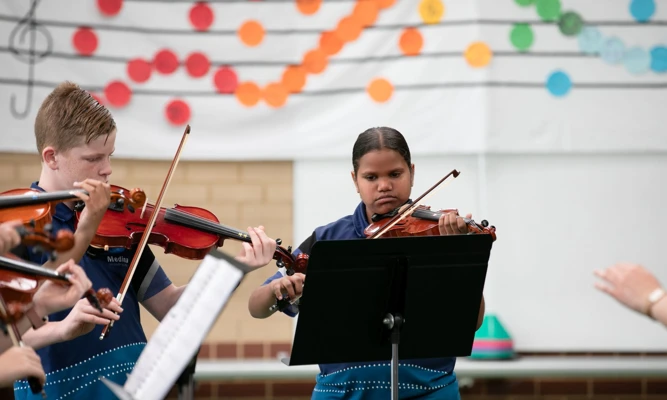 Sandra Hart and other Crescendo students from Medina Primary School playing violin at their End of Year Concert.
