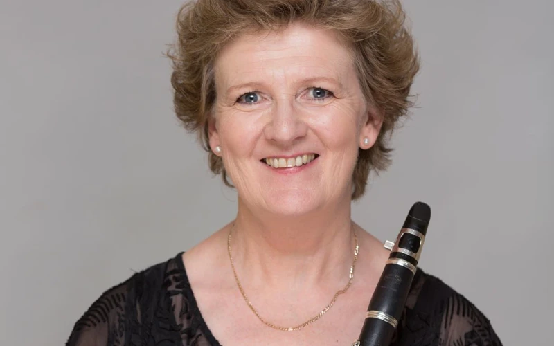 Headshot of Lorna Cook wearing a black lace blouse, holding a clarinet.