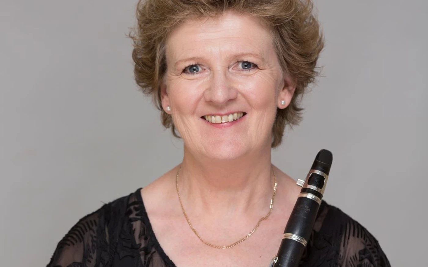 Headshot of Lorna Cook wearing a black lace blouse, holding a clarinet.