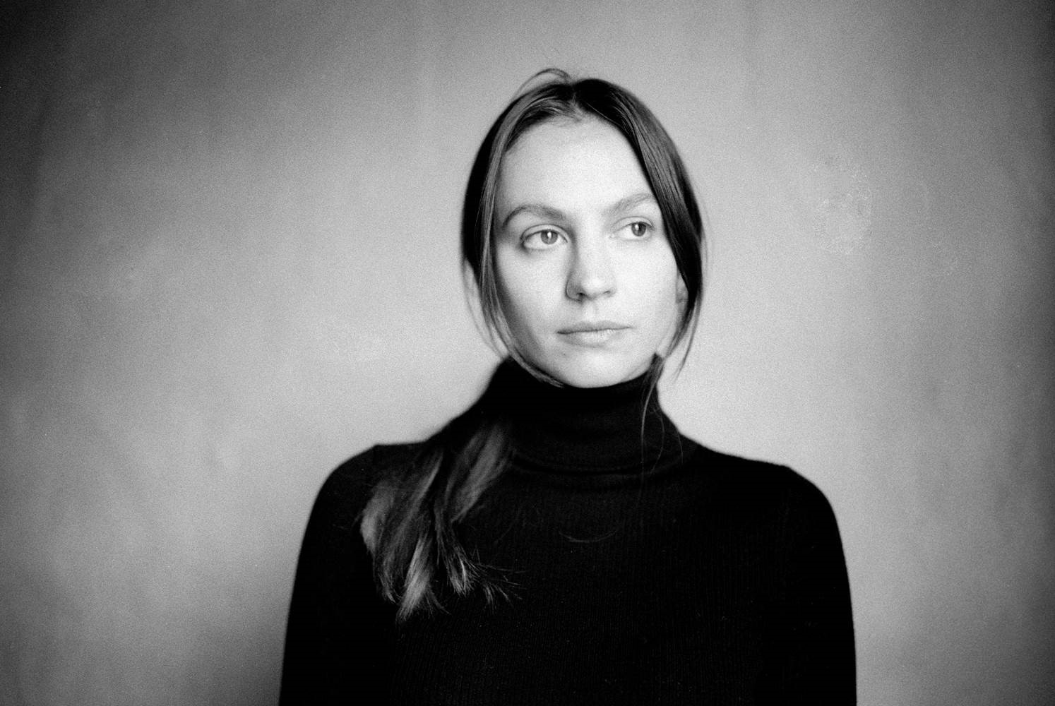 Black & white headshot of Olivia Davies wearing a black turtleneck.
