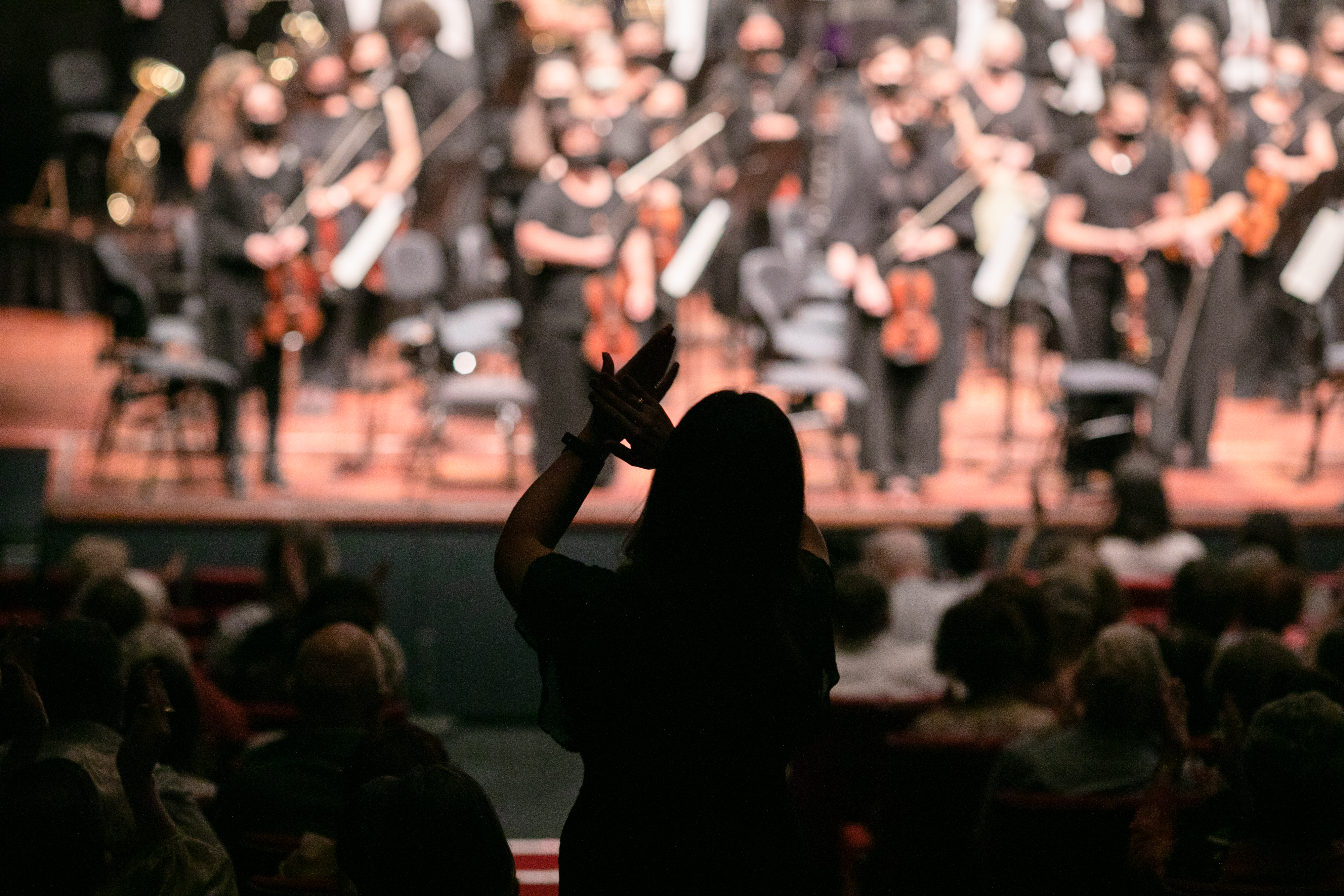 Audience member standing and clapping.