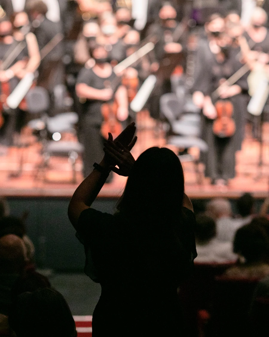 Audience member standing and clapping.