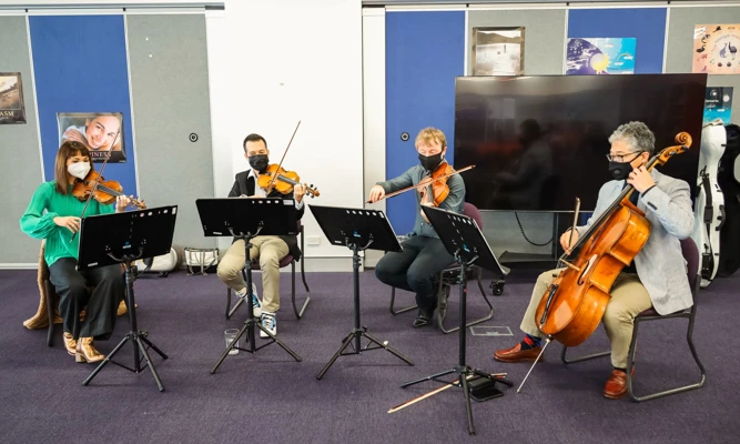 A WASO string quartet performs in a school classroom.