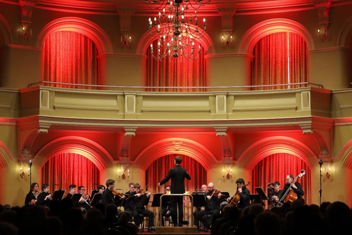 WASO chamber ensemble performing on stage at Government House Ballroom, beneath a decorative chandelier.