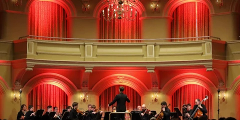 WASO chamber ensemble performing on stage at Government House Ballroom, beneath a decorative chandelier.