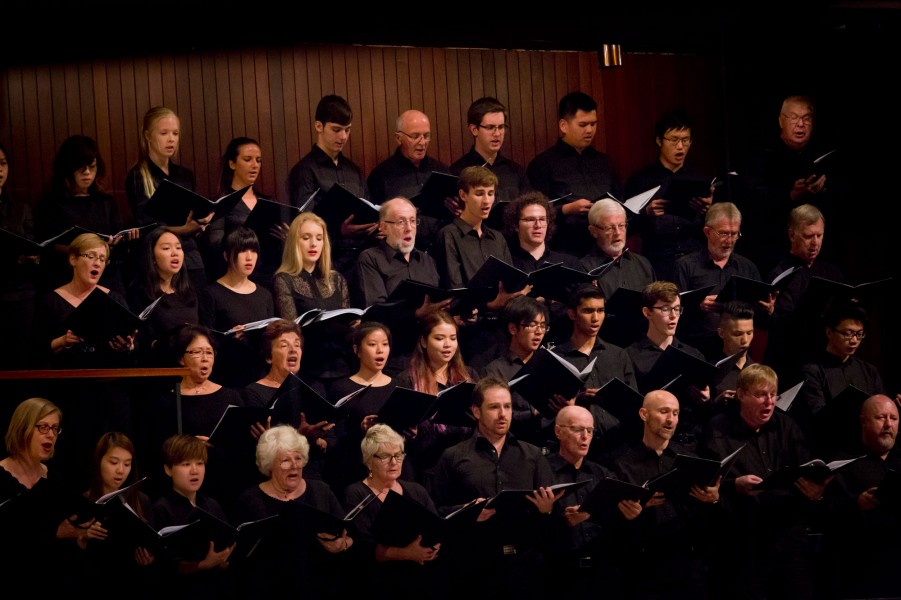 A choir full of people of all ages performs in choir stalls