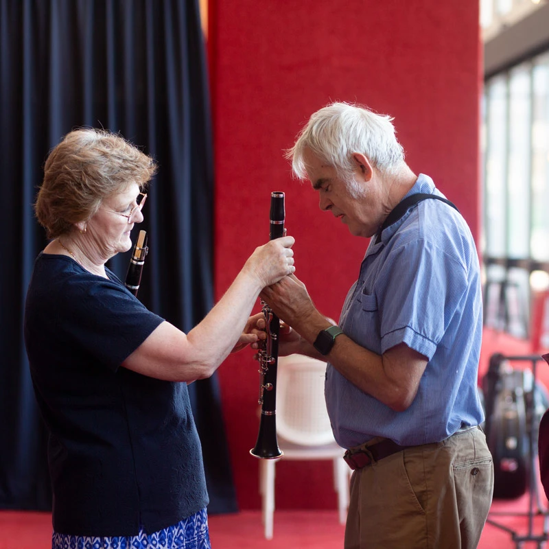 Two people inspect a clarinet