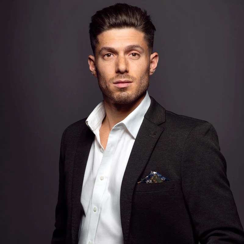 Headshot of Josh Piterman wearing a black suit jacket and white shirt.