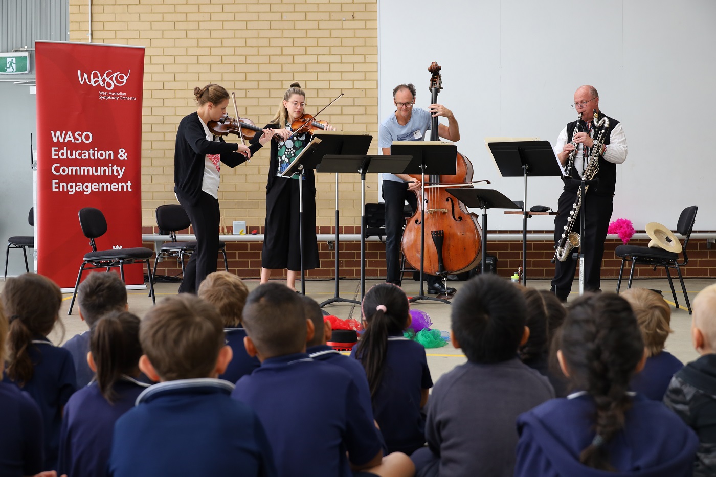 WASO's four-piece Education Chamber Orchestra performs for a group of primary school students in an assembly area.