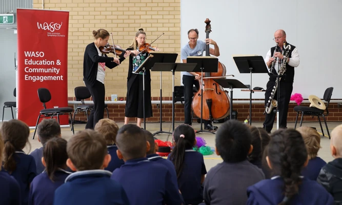 WASO's four-piece Education Chamber Orchestra performs for a group of primary school students in an assembly area.