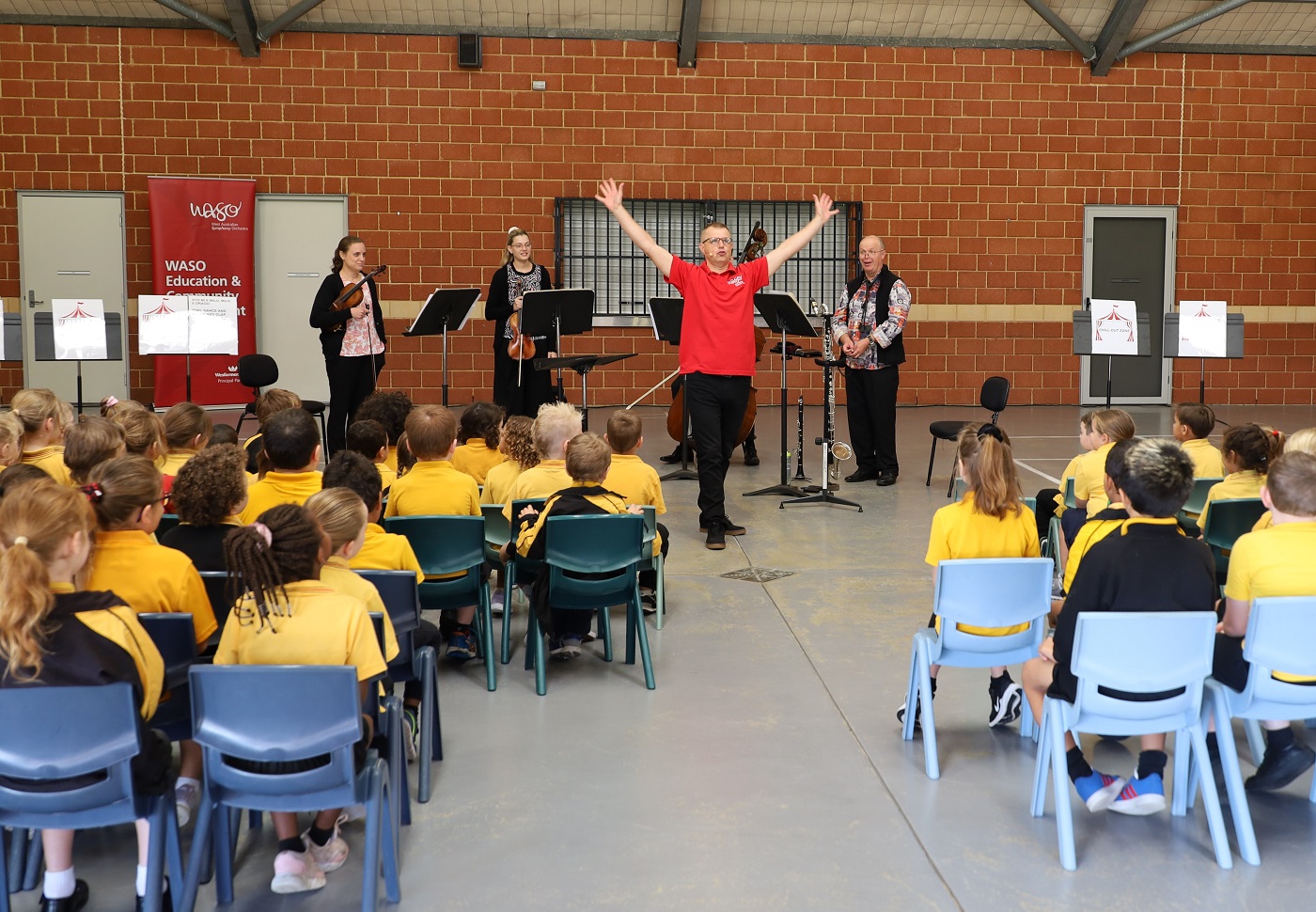 Presenter Lee Stanley and WASO's four-piece Education Chamber Orchestra perform for a group of primary school students.