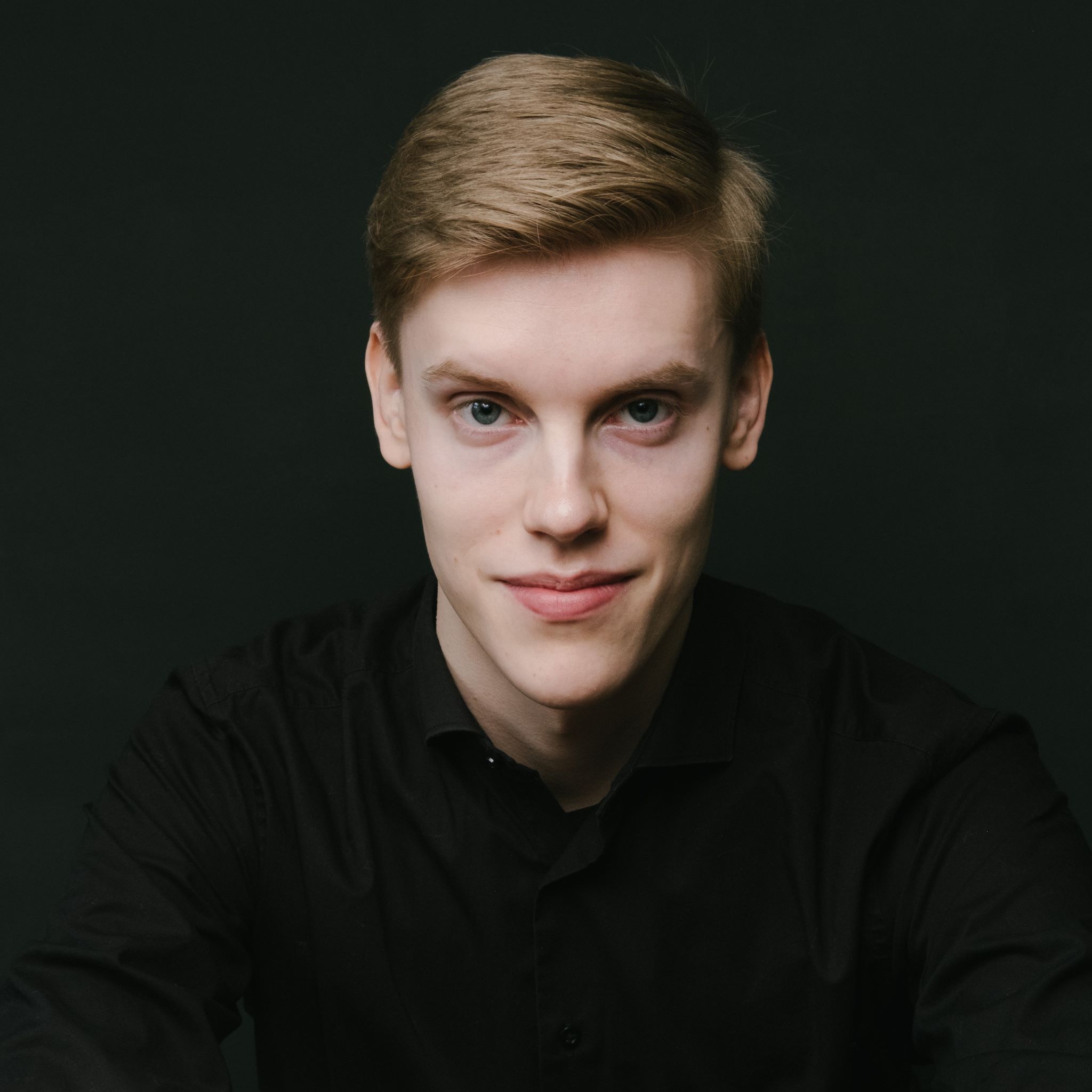 Headshot of Kristian Sallinen wearing a black collared shirt.