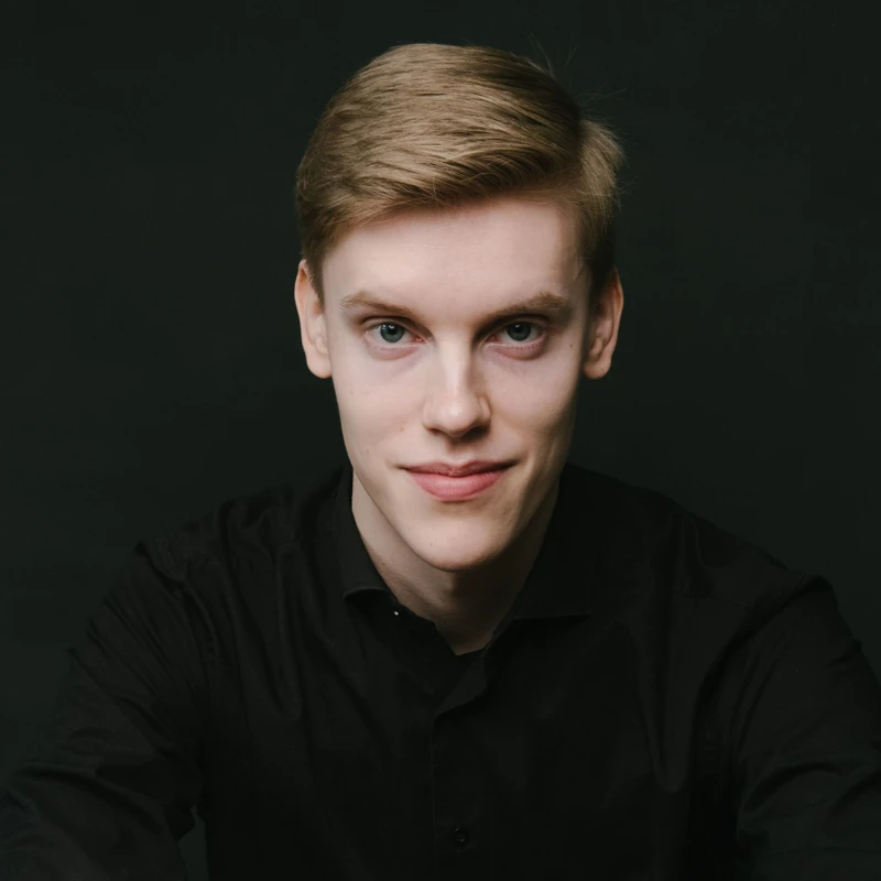 Headshot of Kristian Sallinen wearing a black collared shirt.