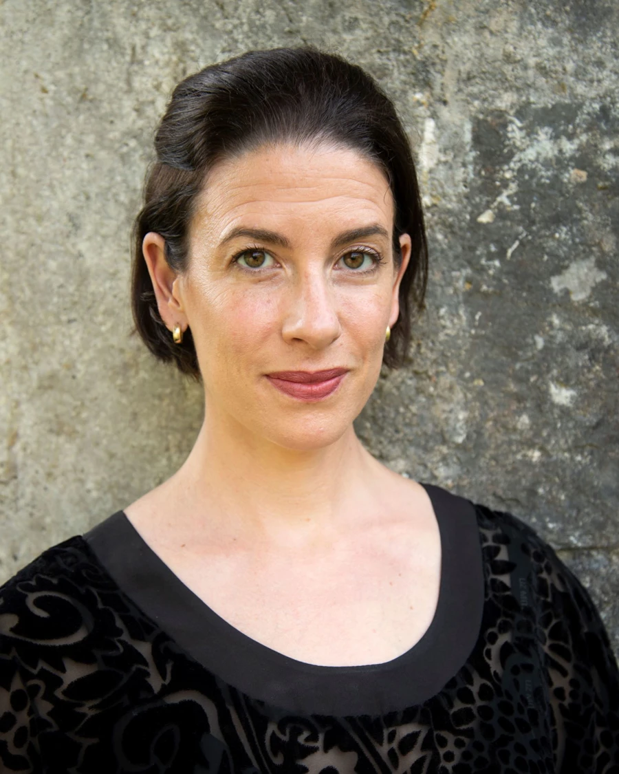 Headshot of Sara Duhig wearing a patterned sheer black top.