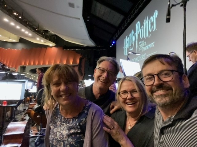 Four WASO bass musicians smiling for a selfie during a rehearsal break, wearing casual attire.
