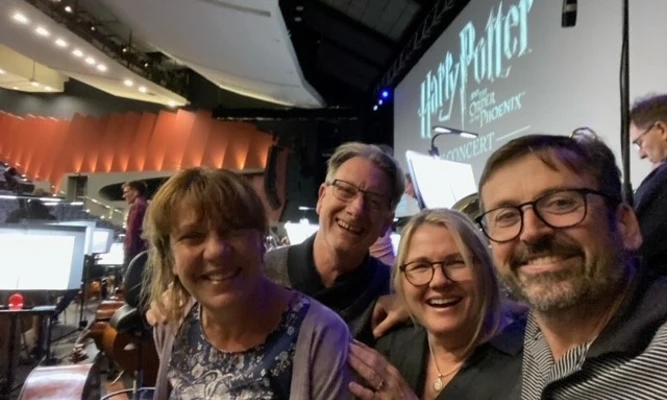 Four WASO bass musicians smiling for a selfie during a rehearsal break, wearing casual attire.