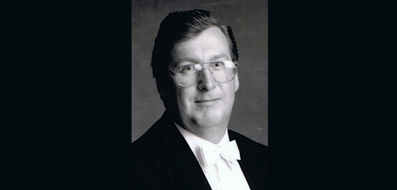 Black & white studio portrait of Philip Holdsworth in a formal suit.