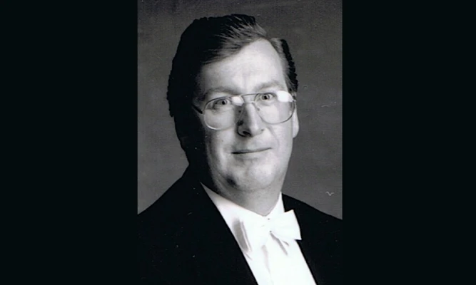 Black & white studio portrait of Philip Holdsworth in a formal suit.