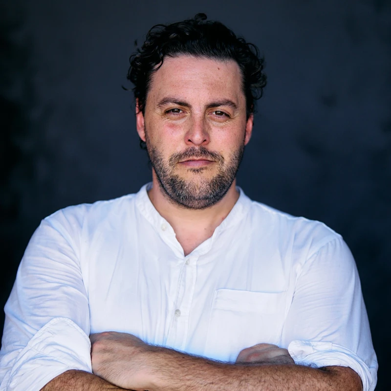 Headshot of Matthew Reardon wearing a white collared shirt with his arms crossed.