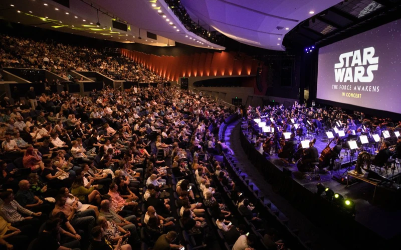 Riverside Theatre WASO performs the music from Star Wars to a full audience at Riverside Theatre, while the film is projected on a large screen.