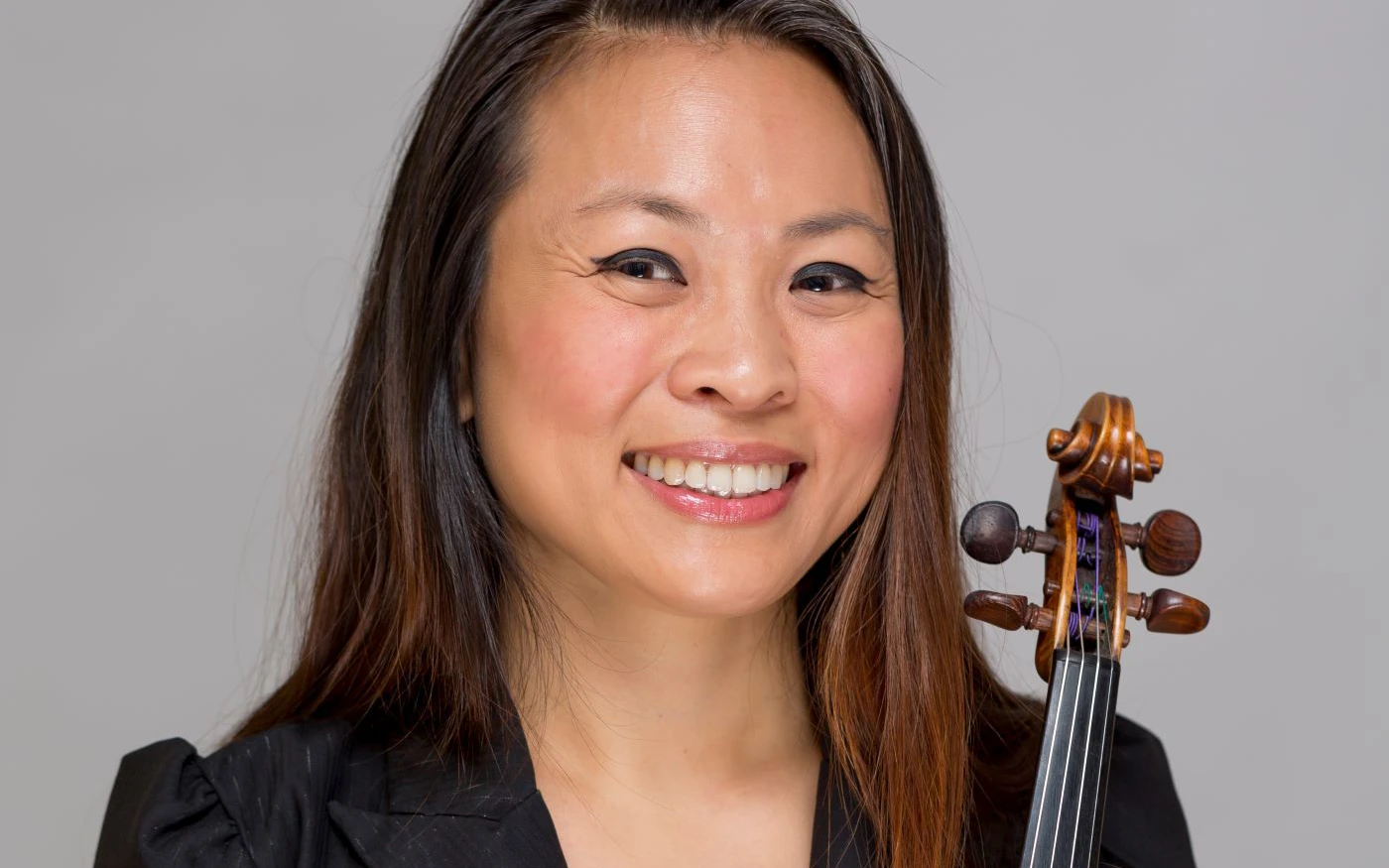 Headshot of Semra Lee wearing a black top, holding a violin.