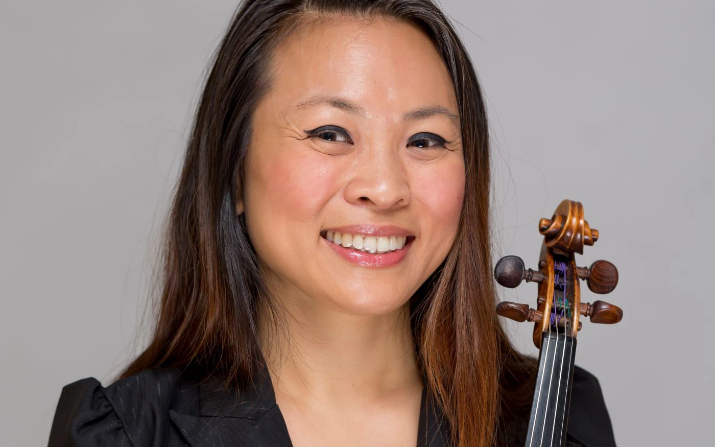 Headshot of Semra Lee wearing a black top, holding a violin.